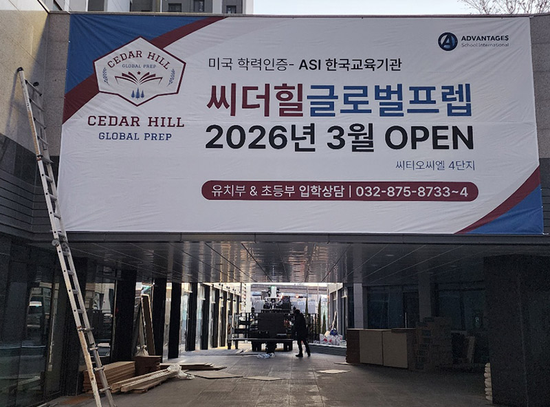 국제학교 개교 안내 대형 현수막 시공 현장 — 사다리 고소작업